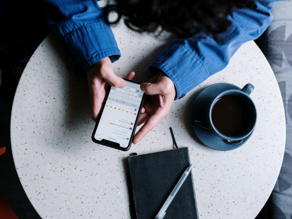 A top-down view of a person using instagram while sitting in a coffee shop, illustrating how to get verified on Instagram